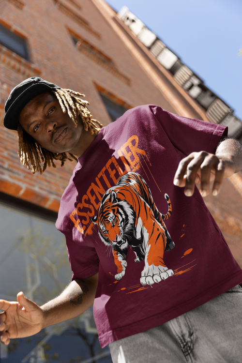 Person wearing a maroon t-shirt with a tiger graphic in an urban setting
