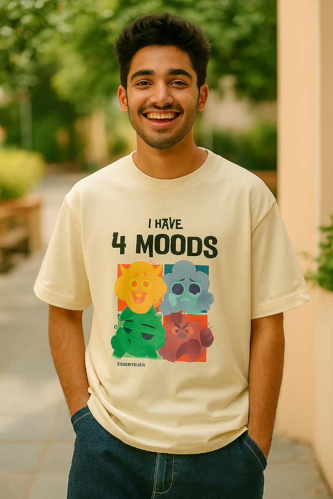 Person wearing a cream t-shirt with colorful graphics and text outdoors.